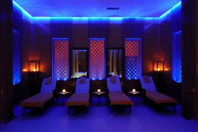 a room with blue lights and chairs and tables with candles at Palais Medina Riad Resort in Fès