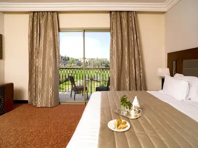 a hotel room with a bed with a table with fruit on it at Palais Medina Riad Resort in Fès