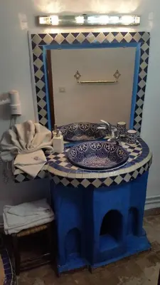 a bathroom with a blue sink and a mirror at Riad Dar Skalli & SPA in Fès