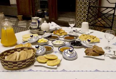 a table with a bunch of food and glasses of orange juice at Riad Dar Skalli & SPA in Fès