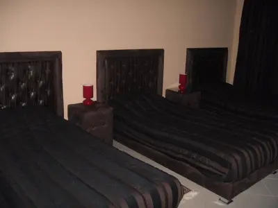 two beds in a room with two red candles at Hôtel Atlas Guercif in Guercif