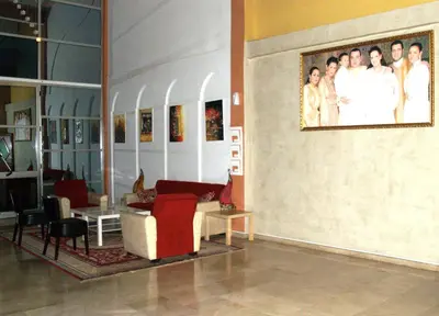 a living room with a couch and a picture on the wall at Hôtel Atlas Guercif in Guercif