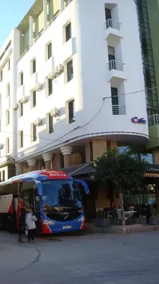 a blue bus parked in front of a building at Hôtel Atlas Guercif in Guercif