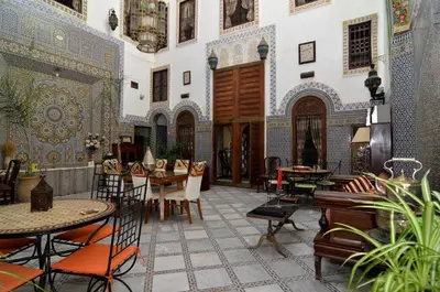 a room with tables and chairs in a building at Riad Le Patio De Fes in Fès