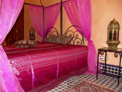 a pink bed with a canopy in a room at Riad Le Patio De Fes in Fès