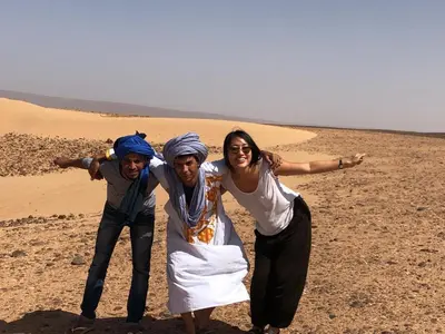 three people posing for a picture in the desert at Dar Yaya in Mhamid