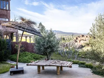 a picnic table and an umbrella in a garden at Dar Tafantant in Marrakech