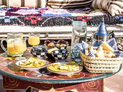 a table with plates of food and drinks on it at Dar Tafantant in Marrakech