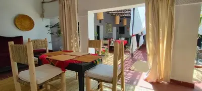 a dining room with a table and chairs in a room at Dar Tadout in Aït Ourir