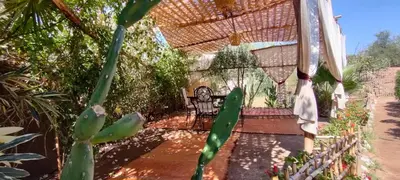 a patio with a chair under a pergola at Dar Tadout in Aït Ourir