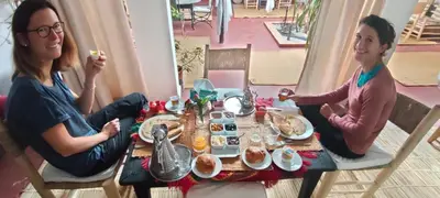 two women sitting at a table eating food at Dar Tadout in Aït Ourir