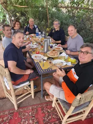 a group of people sitting around a table eating food at Dar Tadout in Aït Ourir
