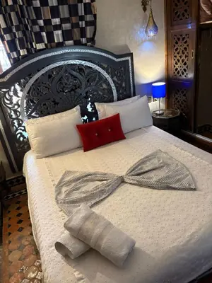 a bed with two pillows on top of it at Riad Golf Stinia 1 in Meknès