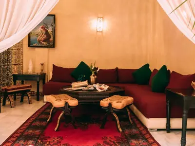 a living room with a red couch and a table at Riad Golf Stinia 1 in Meknès
