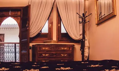 a bedroom with a bed and a dresser and a window at Riad Golf Stinia 1 in Meknès
