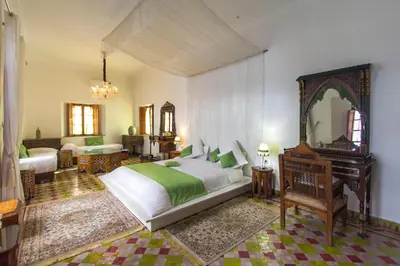 a bedroom with a large bed and a mirror at Riad 53 Fes - Luxury Oasis in Fès