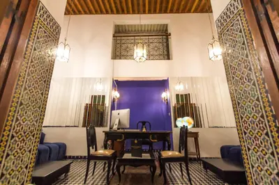 a room with a table and chairs and a purple wall at Riad 53 Fes - Luxury Oasis in Fès