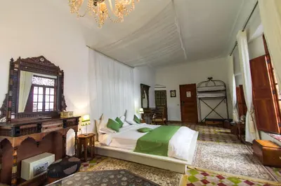 a bedroom with a large bed and a chandelier at Riad 53 Fes - Luxury Oasis in Fès