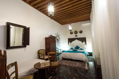 a bedroom with a bed and a table and chairs at Riad 53 Fes - Luxury Oasis in Fès