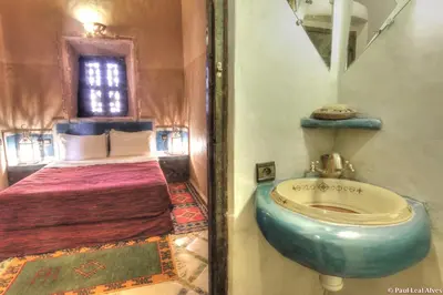 a bathroom with a toilet and a bed at Kasbah Baha Baha in Nkob