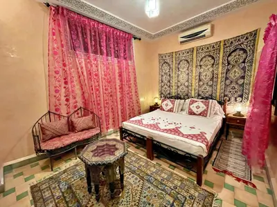 a bedroom with a bed and a chair at Riad Dar Guennoun - Luxury Suites in the Heart of Fes in Fès