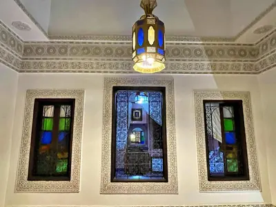 a room with three stained glass windows and a chandelier at Riad Dar Guennoun - Luxury Suites in the Heart of Fes in Fès