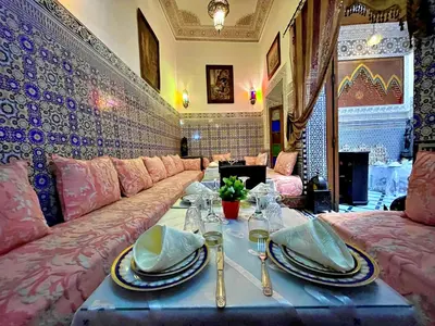 a living room with a couch and a table with dishes on it at Riad Dar Guennoun - Luxury Suites in the Heart of Fes in Fès