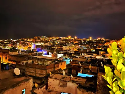 a view of a city at night with lights at Riad Dar Guennoun - Luxury Suites in the Heart of Fes in Fès