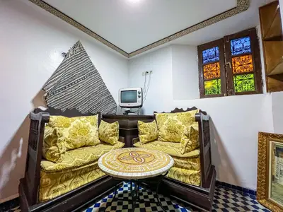 a living room with a couch and a table at Riad Dar Guennoun - Luxury Suites in the Heart of Fes in Fès