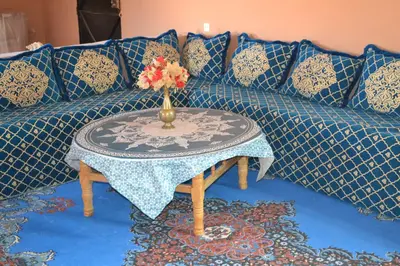 a blue couch with a table with a vase on it at GITE D'etape SIDI FLAH in Sidi Flah