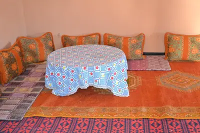 a room with a couch with a table and pillows at GITE D'etape SIDI FLAH in Sidi Flah