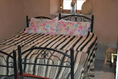 a bed with a black metal frame and pillows at GITE D'etape SIDI FLAH in Sidi Flah