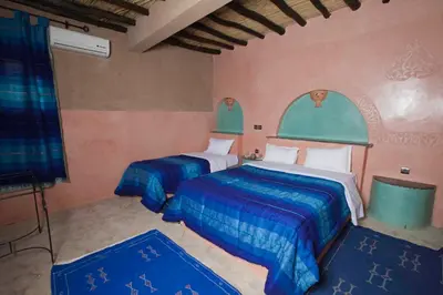 a bedroom with two beds with blue and white sheets at Palmeras Y Dunas Luxery Camp in Merzouga
