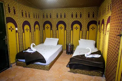 two beds in a room with swans on them at Palmeras Y Dunas Luxery Camp in Merzouga