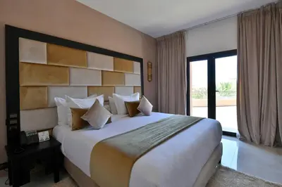 a bedroom with a large bed and a large window at Oscar Hotel by Atlas Studios in Ouarzazate