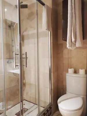 a bathroom with a toilet and a glass shower at Palais Riad Reda & Spa in Fès