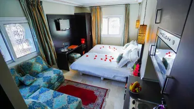 a small bedroom with a bed and a chair at Palais Riad Reda & Spa in Fès
