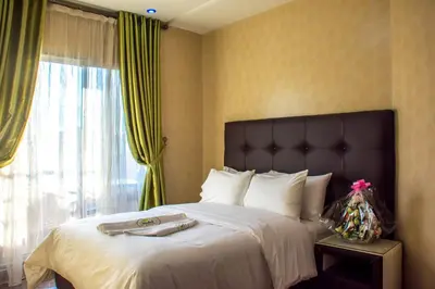 a bedroom with a large bed with a large window at Hôtel Hadaik Ain Asserdoune in Beni Mellal