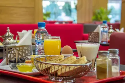 a tray with a plate of food and drinks on a table at Hôtel Hadaik Ain Asserdoune in Beni Mellal