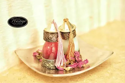 a plate with two candles and flowers on it at Karim Sahara Prestige in Zagora