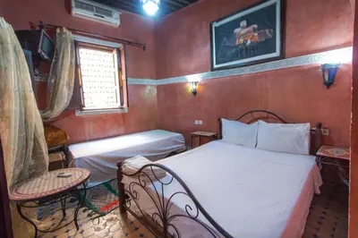a small bedroom with a bed and a chair at Riad Anass Al Ouali in Fès