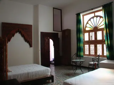 a hotel room with two beds and a window at Riad Sheryne Fes in Fès
