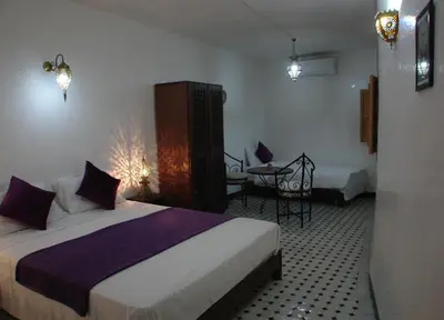 a hotel room with a bed and a table in it at Riad Sheryne Fes in Fès