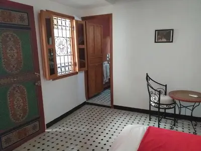 a room with a door and a table and a chair at Riad Sheryne Fes in Fès