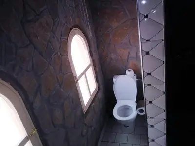 a bathroom with a toilet and a window at Riad Bleu Afriqua in Boumalne