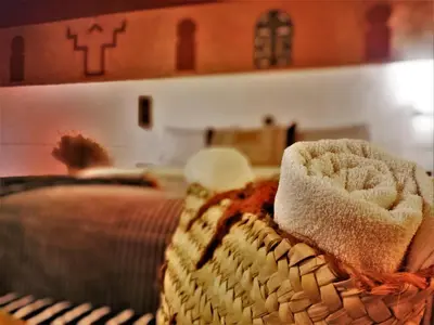 a basket with towels on it next to a bed at Riad Bleu Afriqua in Boumalne
