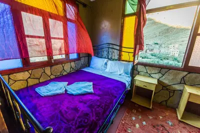 a bed in a room with a colorful window at Les Jardins De Todgha gorges de todra tinghir in Aït Baha