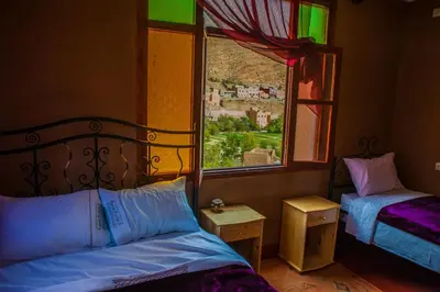 a bedroom with two beds and a window with a view at Les Jardins De Todgha gorges de todra tinghir in Aït Baha