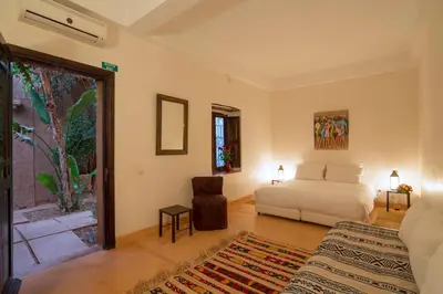 a bedroom with a bed and a chair in a room at Ecolodge Quaryati Marrakech in Douar Tounsi