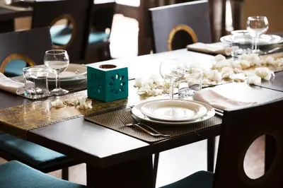 a table with plates and wine glasses on it at Ecolodge Quaryati Marrakech in Douar Tounsi